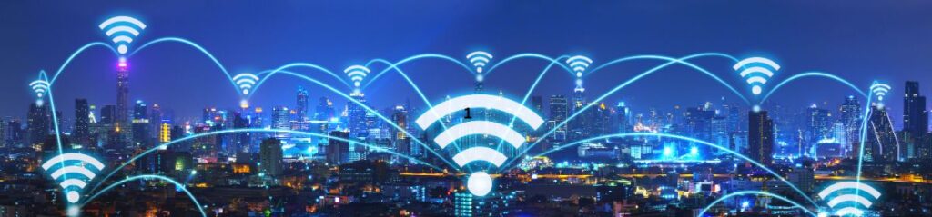 City skyline at night with glowing Wi-Fi symbols and connection lines, representing wireless communication and smart city connectivity