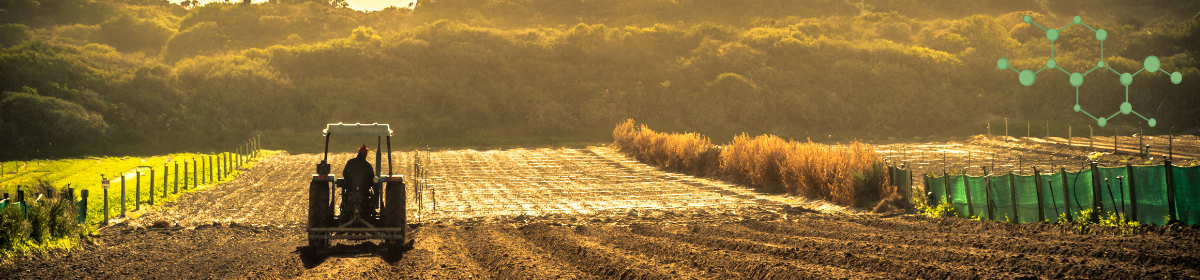 A farmer on a tractor ploughing a sunlit field, with a backdrop of green hills and a molecular structure overlay, symbolising agricultural innovation and chemical formulation.