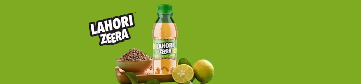 Image of a LAHORI ZEERA beverage bottle placed beside cumin seeds and sliced lemons on a wooden tray, with a green background and the LAHORI ZEERA logo displayed prominently.