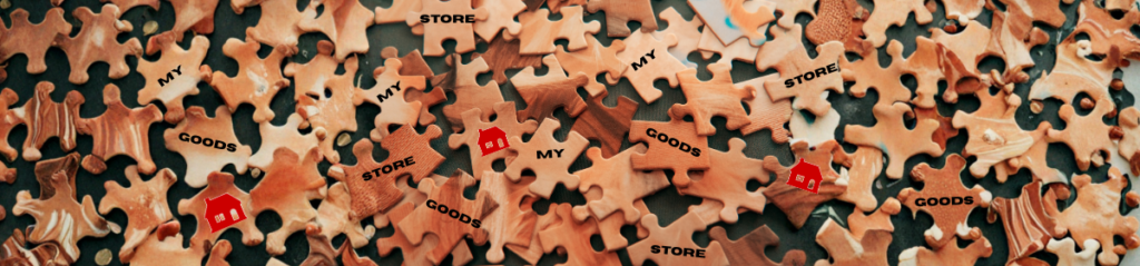 Scattered jigsaw puzzles with few puzzles with the words 'STORE', 'MY' and 'GOODS' and the images of a red house.