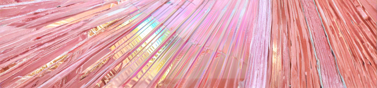 Close-up view of pink-tinted glass fibers arranged in parallel strands, showing fine linear textures and an iridescent sheen
