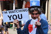 The featured shows a man wearing a uncle sam costume and holding the signage " i m watching you". To read more click here.